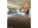 Cozy living room featuring ceiling fan, carpet flooring, and a kitchen island with breakfast bar at 2425 W Bronco Butte Trl # 2028, Phoenix, AZ 85085