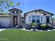 Charming home boasts a well-manicured lawn and stylish stone accents, creating an inviting curb appeal at 25602 S 229Th Pl, Queen Creek, AZ 85142