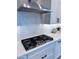 Modern kitchen featuring a stainless steel range hood and sleek white subway tile backsplash at 25602 S 229Th Pl, Queen Creek, AZ 85142