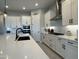 Modern kitchen with white cabinets, black hardware, stainless steel appliances, and a large island at 25602 S 229Th Pl, Queen Creek, AZ 85142