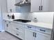 Updated kitchen with white cabinets, subway tile backsplash, black hardware, and stainless steel hood at 25602 S 229Th Pl, Queen Creek, AZ 85142