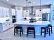 Bright kitchen features a large island, white cabinetry, stainless steel appliances and bar stool seating at 25602 S 229Th Pl, Queen Creek, AZ 85142