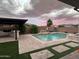 Sparkling pool with lush landscaping, a built-in waterfall, and an outdoor kitchen area, ideal for entertaining at 25602 S 229Th Pl, Queen Creek, AZ 85142