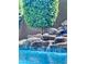 Beautiful pool with a stone waterfall feature and lush landscaping, perfect for relaxation at 25602 S 229Th Pl, Queen Creek, AZ 85142