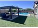 Inviting outdoor area featuring a pool, spa, pergola covered outdoor kitchen, and artificial turf at 25602 S 229Th Pl, Queen Creek, AZ 85142
