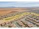 Expansive aerial view of a desert community, golf course and distant mountains in this Arizona neighborhood at 2599 E San Mateo Dr, Casa Grande, AZ 85194
