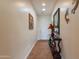Well-lit hallway with a decorative table, mirror, and tile flooring, leading to the home's entrance at 2599 E San Mateo Dr, Casa Grande, AZ 85194