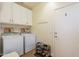 Well-equipped laundry room features a washer, dryer, overhead cabinets, and storage racks at 2599 E San Mateo Dr, Casa Grande, AZ 85194