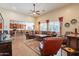 Spacious living room with a ceiling fan, windows offering natural light, and an open layout to the kitchen at 2599 E San Mateo Dr, Casa Grande, AZ 85194