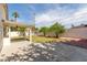 Landscaped backyard with a covered patio, green lawn, and fruit trees at 3307 E Roveen Ave, Phoenix, AZ 85032