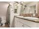 Bathroom with double sinks, granite counters, decorative mirrors, and walk-in shower at 3307 E Roveen Ave, Phoenix, AZ 85032