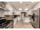 Updated kitchen with white cabinets, granite countertops, stainless steel appliances, and travertine floors at 3307 E Roveen Ave, Phoenix, AZ 85032