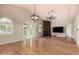 Spacious living room featuring a wood-burning fireplace, wood floors, and large windows for lots of natural light at 3307 E Roveen Ave, Phoenix, AZ 85032