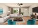 Bright living room with a large sectional sofa, wood floors, and natural light from the large window at 3307 E Roveen Ave, Phoenix, AZ 85032