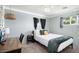 Cozy bedroom with a minimalist design, a comfortable bed, and natural light from the windows at 3330 E Cypress St, Phoenix, AZ 85008