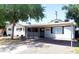 Charming single-story home with a covered carport, white exterior, and mature trees at 3330 E Cypress St, Phoenix, AZ 85008
