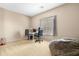 Neutral bedroom with a work desk, a gray bean bag chair, and a bright window at 36265 W Alhambra St, Maricopa, AZ 85138