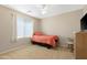 Bright bedroom featuring a single bed, blinds, and a small rocking chair next to a dresser at 36265 W Alhambra St, Maricopa, AZ 85138
