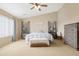 Bedroom showcasing a ceiling fan, large window, neutral decor, and cozy furnishings at 36265 W Alhambra St, Maricopa, AZ 85138