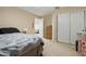 Bedroom with an open door, double closets, neutral carpet, and bed with a patterned comforter at 36265 W Alhambra St, Maricopa, AZ 85138