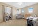 Well-lit Bedroom with beige walls, carpet flooring, and a gray crib and changing table at 36265 W Alhambra St, Maricopa, AZ 85138
