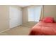 Bright bedroom with blinds, double mirrored closet and a single bed dressed with a red comforter at 36265 W Alhambra St, Maricopa, AZ 85138