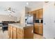 Open kitchen with wood cabinets, granite countertops, and stainless steel refrigerator at 36265 W Alhambra St, Maricopa, AZ 85138