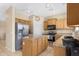 Well-lit kitchen with wood cabinets, granite countertops, and stainless steel appliances at 36265 W Alhambra St, Maricopa, AZ 85138