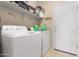 Convenient laundry room equipped with modern washer and dryer, shelving and ample counter space at 36265 W Alhambra St, Maricopa, AZ 85138