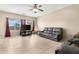 Inviting living room featuring tile floors, a large window, and a leather sofa at 36265 W Alhambra St, Maricopa, AZ 85138