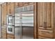 Stainless steel refrigerator and double ovens set among custom cabinets and drawers at 3731 E Halifax Cir, Mesa, AZ 85205