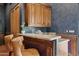 This home features a stylish bar area with granite countertops, custom wood cabinetry, and comfortable seating at 3731 E Halifax Cir, Mesa, AZ 85205