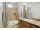 Bathroom with stone-look tiled walls, granite vanity and shower/tub combination at 3731 E Halifax Cir, Mesa, AZ 85205