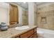 Bathroom features a granite countertop, wood cabinet, and tile surround on the tub/shower at 3731 E Halifax Cir, Mesa, AZ 85205