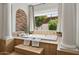 The luxurious bathtub is set inside a brick alcove by a window with views of the yard at 3731 E Halifax Cir, Mesa, AZ 85205