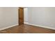 This bedroom showcases wood floors, neutral paint, and a wooden door leading to another room at 3731 E Halifax Cir, Mesa, AZ 85205