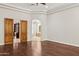 Spacious main bedroom with dark wood floors and an ensuite bathroom through an arched doorway at 3731 E Halifax Cir, Mesa, AZ 85205