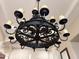 Close up of wrought iron chandelier featuring yellow glass shades at 3731 E Halifax Cir, Mesa, AZ 85205