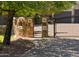 A home with a black metal gate and a brick driveway with stone accents and mature landscaping at 3731 E Halifax Cir, Mesa, AZ 85205