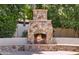 Stone fireplace and seating in backyard at 3731 E Halifax Cir, Mesa, AZ 85205