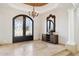 Elegant foyer featuring a decorative iron door, chandelier, and travertine flooring at 3731 E Halifax Cir, Mesa, AZ 85205