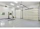 This home features a large garage with two doors, modern lighting, and an installed car lift at 3731 E Halifax Cir, Mesa, AZ 85205