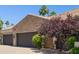 Close up of home featuring 2 garages with a stone facade, mature landscaping and brick driveway at 3731 E Halifax Cir, Mesa, AZ 85205