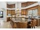 Bright, spacious kitchen featuring a brick accent wall, stone countertops, and custom wood cabinets at 3731 E Halifax Cir, Mesa, AZ 85205