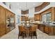 Open concept kitchen featuring wood cabinets, brick accents, and a large island with bar seating at 3731 E Halifax Cir, Mesa, AZ 85205