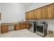Spacious laundry room with stainless steel washer/dryer and granite countertops and tile floors at 3731 E Halifax Cir, Mesa, AZ 85205