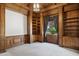 Cozy living room highlighted by wood paneled walls and shelving with a view of the yard at 3731 E Halifax Cir, Mesa, AZ 85205