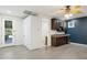 Stylish living room features dark cabinets with granite counters, a mini fridge, and sleek gray floors at 3731 E Halifax Cir, Mesa, AZ 85205