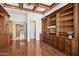 Elegant living room with custom built-in wood cabinetry, hardwood floors, and coffered ceilings at 3731 E Halifax Cir, Mesa, AZ 85205