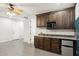 Open-concept living room with dark cabinets with granite counters, a mini fridge, and sleek gray floors at 3731 E Halifax Cir, Mesa, AZ 85205